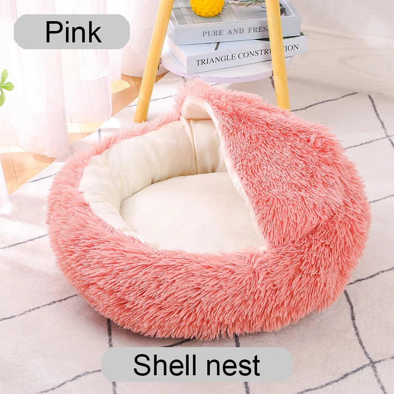 Pink shell nest pet bed on a light wooden floor.
