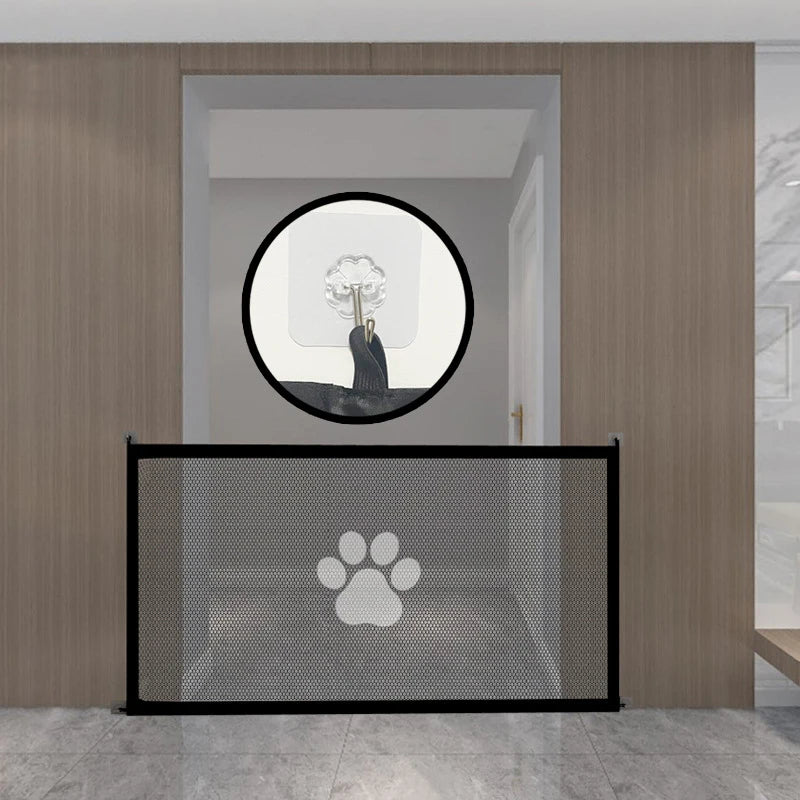 Pet gate with paw print design in a room with wooden walls and a round mirror.
