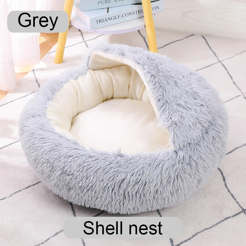 Fluffy shell-shaped pet bed on a white floor with books in the background