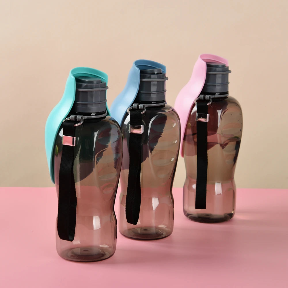 Three transparent water bottles with colorful lids on a pink surface and beige background
