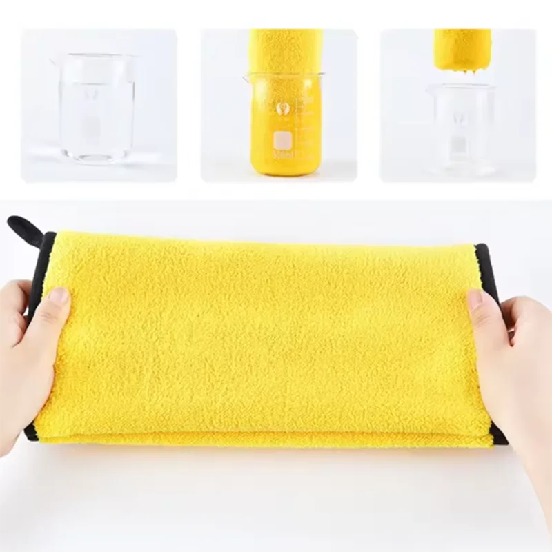 Yellow microfiber towel held by hands with cleaning products in the background
