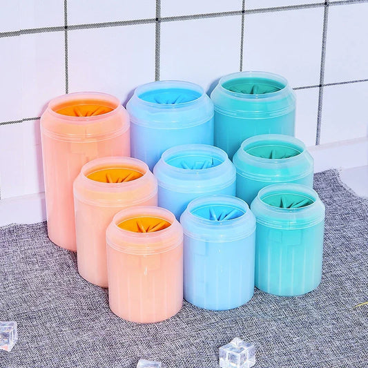 Set of colorful soft silicone pet paw cleaner on a textured surface with a tiled wall background.
